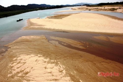 Một bãi cát rộng mênh mông giữa lòng sông, chỉ còn những dòng chảy nhỏ hai bên bờ