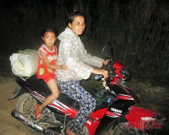 Bà mẹ này tranh thủ đi chở nước và đèo theo con để nó được tắm táp
