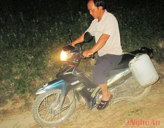 ... và chở nước về bằng xe máy trên đèo dốc