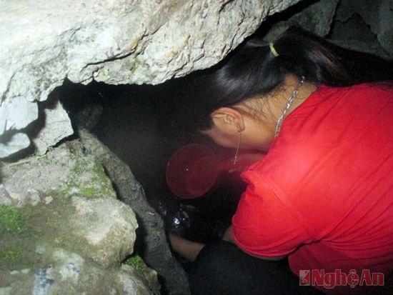 Chị Và Y Phua múc nước trong hốc đá