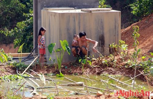 Người đàn ông này bế con ra vườn hái rau, nhưng các loại rau đã bị nắng nóng làm khô héo.