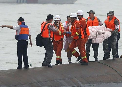 Nhân viên cứu hộ đưa một người còn sống từ dưới tàu chìm lên bờ hôm 2/6. Ảnh: AP