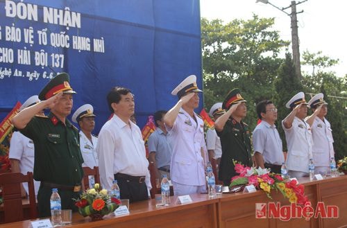 Các đại biểu nghiêm trang làm lễ chào cờ.
