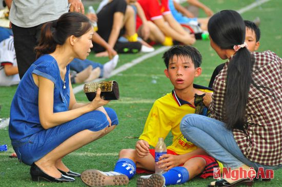 Cầu thủ Quỳnh Lưu được mẹ và dì chăm sóc tận tình sau hiệp đấu.