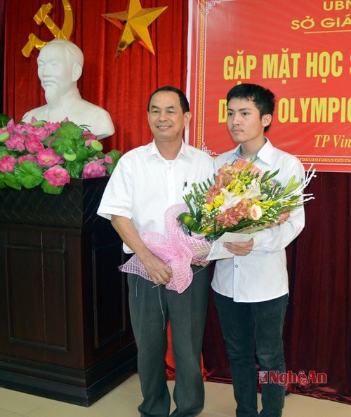 Thầy giáo Đậu Văn Mùi tặng hoa động viên em Nguyễn Ngọc Khánh tự tin bước vào kỳ thi Olimpic Vật lý Quốc tế.