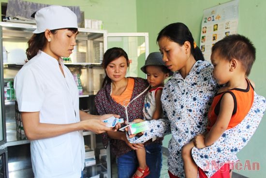 Cán bộ Trạm Y tế xã Châu Thuận (Quỳ Châu) hướng dẫn người dân sử dụng thuốc.