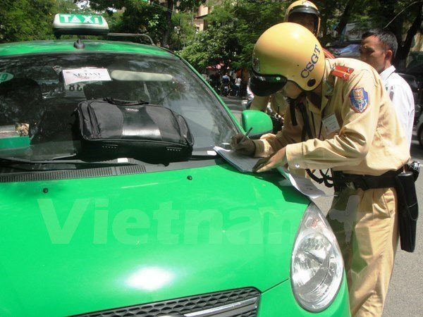 Cảnh sát giao thông xử phạt xe taxi vi phạm Luật giao thông. (Ảnh: Việt Hùng/Vietnam+)