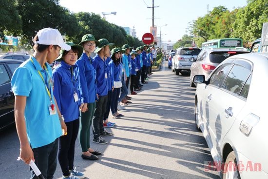 Sinh viên tình nguyện phân luồng giao thông trước điểm thi.Ảnh: Mỹ Hà