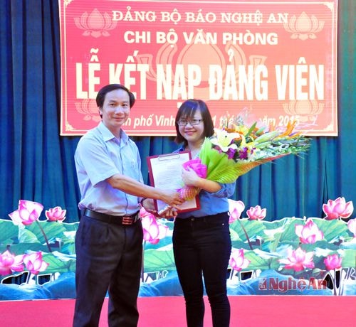 Đồng chí Trần Văn Hùng - Phó Bí thư Đảng ủy - Phó Tổng Biên tập trao quyết định kết nạp đảng cho đồng chí Trần Thị Phương Chi.