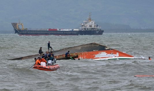 Đội cứu hộ tìm cách lật lại chiếc phà gặp nạn. Ảnh: Reuters.