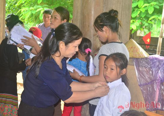 Lãnh đạo Báo Nghệ An tặng quần áo cho học sinh bản Đình Tài, xã Xiêng My (Tương Dương). Ảnh: Nguyên Khoa