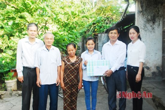 Đại diện Báo Nghệ An và Phòng Giáo dục huyện Yên Thành trao số tiền ủng hộ cho em Lan Anh  