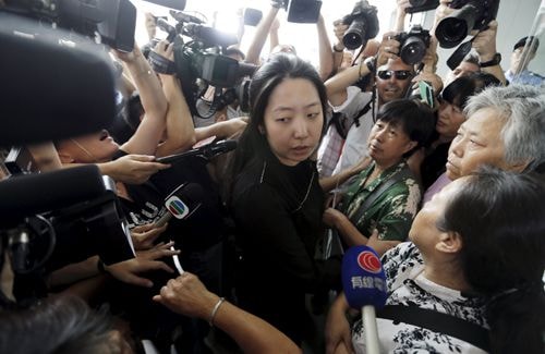 Một nhân viên Malaysia Airlines bị người nhà nạn nhân vây quanh tại văn phòng. Ảnh: Reuters