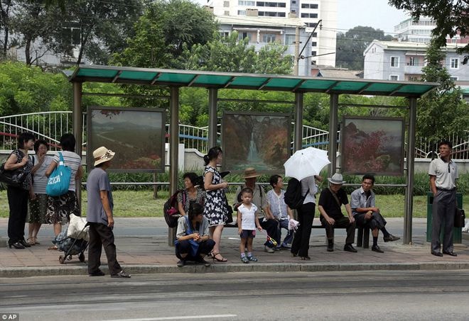 Nhóm phụ nữ đứng trò chuyện cùng nhau trong lúc chờ xe buýt ở Bình Nhưỡng. Ảnh: AP.