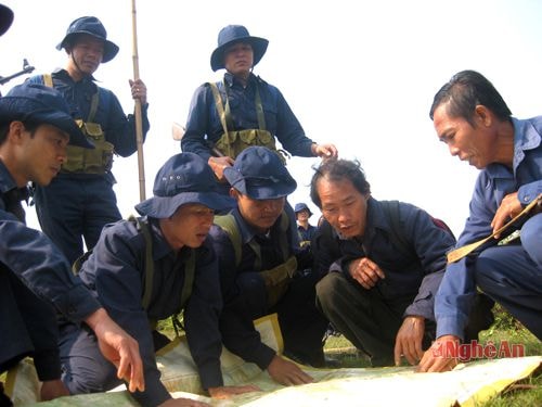 Ông Phai Đa Giàng (thứ 2 từ phải sang) xác định sơ đồ hỗ trợ Đội Quy tập tìm kiếm hài cốt liệt sỹ tại Lào.