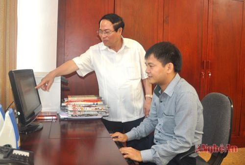 Đồng chí Nguyễn Quang Trạch trao đổi nghiệp vụ với cán bộ Văn phòng UBND tinh.  Ảnh: P.V