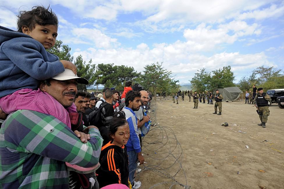 Cảnh sát đặc nhiệm của Macedonia làm nhiệm vụ trước hàng nghìn người di cư chờ đợi tại đường biên giới giữa Macedonia và Hy Lạp hòng tiến vào lãnh thổ Macedonia hôm 21/8. Ảnh: Reuters.