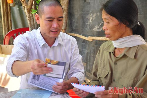 Đại diện báo Tiền Phong tại Nghệ An, ông Trần Quang Long, trao tặng những món quà của bạn đọc cho bà  Nguyễn Thị Kim, mẹ em Nguyễn Anh Tuấn
