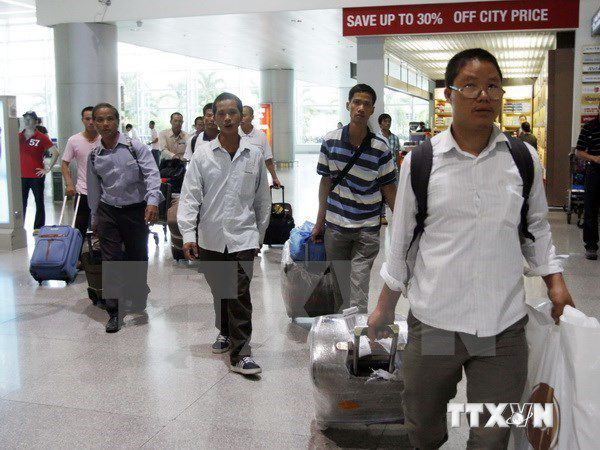 Lao động Việt Nam đi làm việc ở nước ngoài trở về. Ảnh: TTXVN