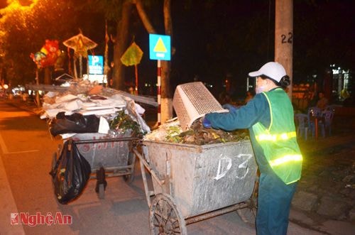 l Công nhân công ty TNHH MTV môi trường đô thị Nghệ An  thu dọn rác thải trên đường Phan Đăng Lưu (TP. Vinh). Ảnh: l.M