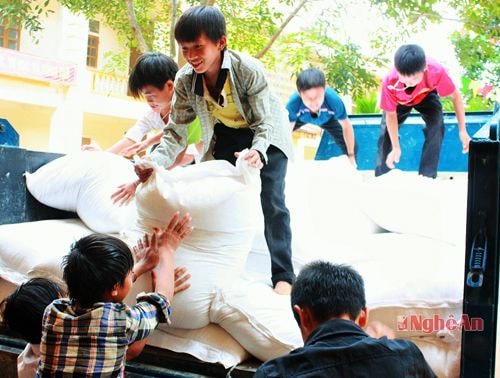Các em học sinh ở Nậm Càn vận chuyển gạo