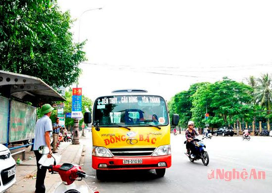 Xe buýt Đông Bắc đón - trả khách trên đường Lê Duẩn (TP. Vinh).