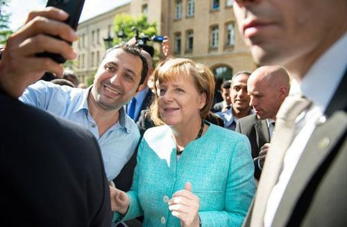Người tị nạn tranh nhau chụp ảnh selfie với bà Merkel. Ảnh: AFP