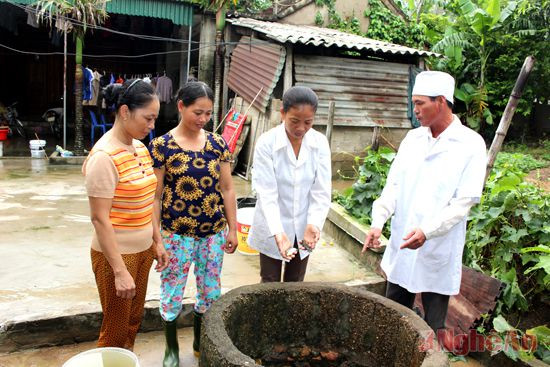 Cán bộ y tế xã Hưng Lĩnh (Hưng Nguyên) hướng dẫn người dân diệt lăng quăng, bọ gậy phòng tránh bệnh sốt xuất huyết.