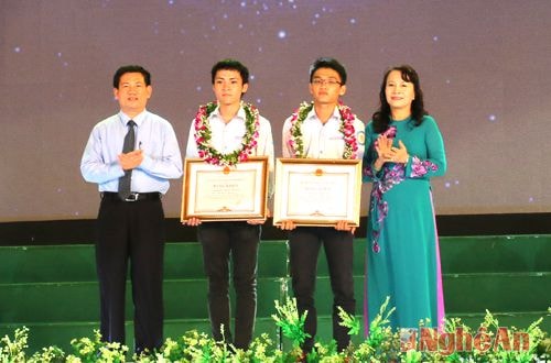 Thứ trưởng Nguyễn Thị Nghĩa và đồng chí Hồ Đức Phớc tặng Bằng khen  và phần thưởng cho 2 học sinh đạt giải quốc tế. Ảnh: mỹ hà