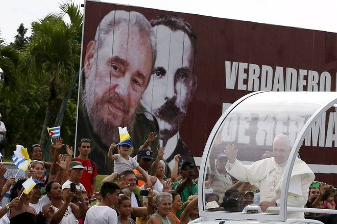 Giáo hoàng vẫy chào các tín đồ khi đi qua tấm biển có hình cựu lãnh tụ Fidel Castro và anh hùng dân tộc Cuba Jose Marti bên ngoài sân bay ở La Habana. Ông dự kiến sẽ có cuộc gặp với ông Fidel Castro trong chuyến thăm này. Nguồn: AFP.