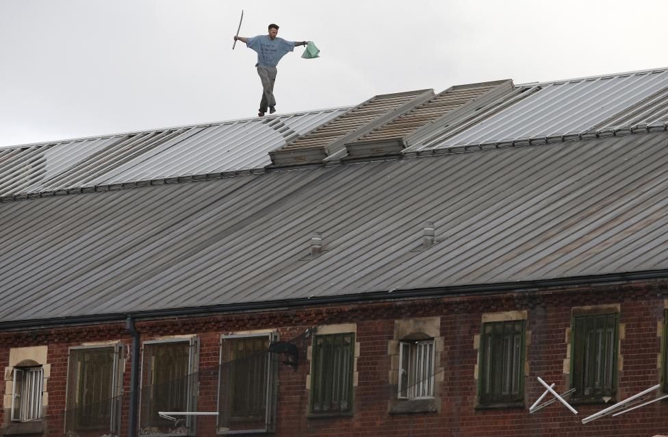 Tù nhân Stuart Horner, phạm tội giết người, đi dọc mái nhà tù Strangeways tại Manchester, Anh hôm 15/9 để bày tỏ thái độ phản đối về các điều kiện trong nhà tù.