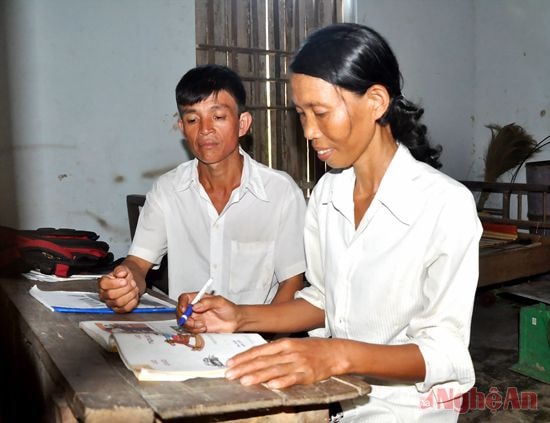 Anh Trần Văn Kính hướng dẫn vợ tập đọc.