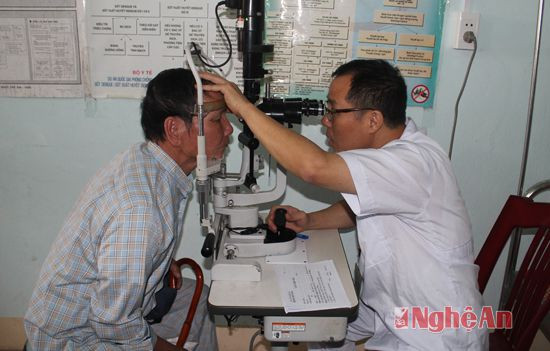 Cán bộ y tế kiểm tra thị lực cho bệnh nhân tại Trạm Y tế xã Diễn Thành