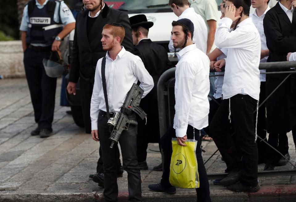 Một thanh niên Do thái trang bị vũ khí hạng nặng nhìn về phía hiện trường nơi một công dân Palestine bị các lực lượng an ninh Israel bắn hạ sau khi người này dùng dao tấn công 2 cảnh sát hôm 10/10 tại Cổng Damascus, Jerusalem. Ảnh: AFP.