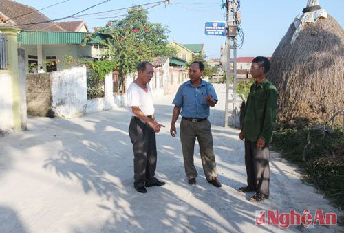  Đồng chí đảng viên Nguyễn Văn Phúc (ngoài cùng bên trái) đang trao đổi với cán bộ xã, xóm về hiệu quả của con đường giao thông bê tông mang lại với cộng đồng