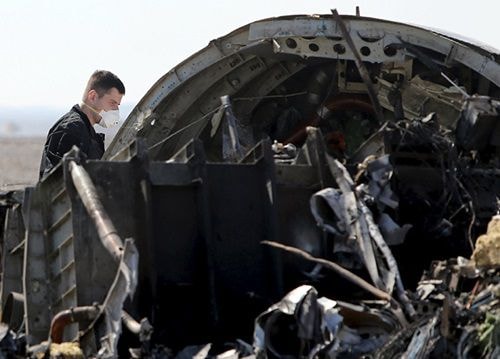 Nhân viên điều tra Nga kiểm tra một mảnh vỡ của máy bay tại hiện trường. Ảnh: Reuters