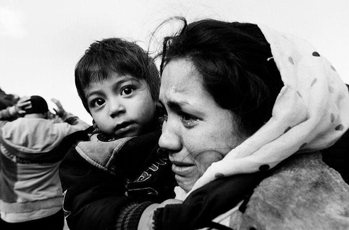 Người mẹ Afghanistan ôm chặt đứa con, bật khóc sau hành trình lênh đênh trên biển.