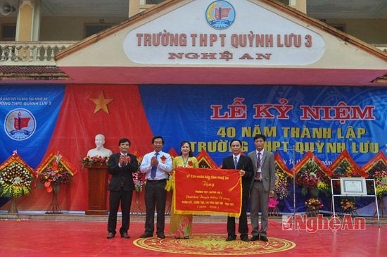 Đồng chí Lê Đức Cường - Bí thư Huyện ủy Quỳnh Lưu trao bức trướng của Chủ tịch UBND tỉnh cho Ban giám hiệu nhà trường