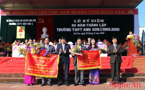 Đồng chí Lê Hồng Vinh - Ủy viên Ban Thường vụ Tỉnh ủy, Bí thư Huyện ủy Anh Sơn và đại diện lãnh đạo Sở GD -ĐT tặng 2 bức trường của tỉnh cho nhà trường.