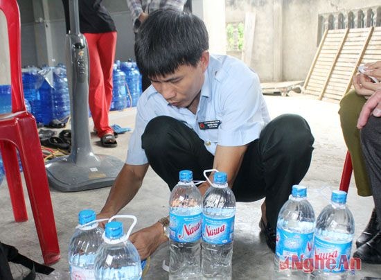 Đoàn thanh tra liên ngành tỉnh lấy mẫu nước sản phẩm nước đóng chai của 1 cơ sở sản xuất nước uống đóng chai. 