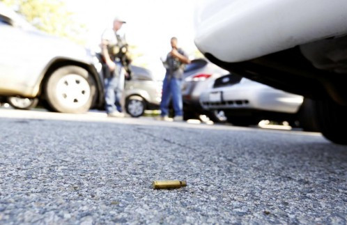 Một vỏ đạn nằm trên mặt đất trong khi các sỹ quan cảnh sát bảo vệ hiện trường sau vụ xả súng tại trung tâm dịch vụ xã hội ở San Bernardino hôm 2/12.