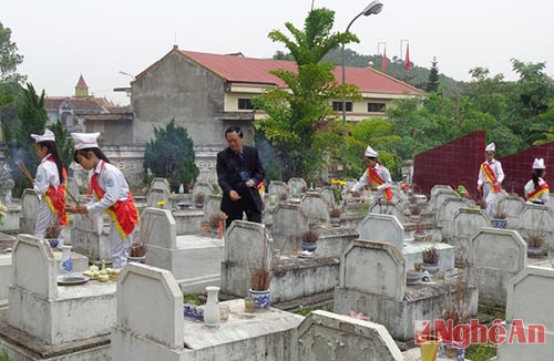 Lãnh đạo huyện và các em học sinh thắp hương lên phần mộ các liệt sỹ