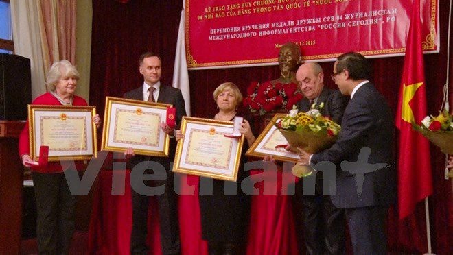Công sứ Nguyễn Hùng trao Huy chương cho các phóng viên. (Ảnh: Duy Trinh/Vietnam+)