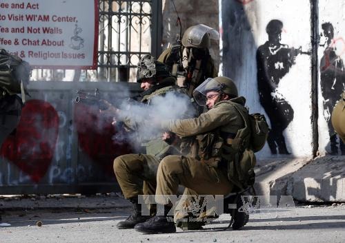 Binh sĩ Israel bắn đạn cao su và hơi cay vào người biểu tình bạo động Palestine ở thành phố Bethlehem, Khu Bờ Tây ngày 18/12. Ảnh: AFP/ TTXVN