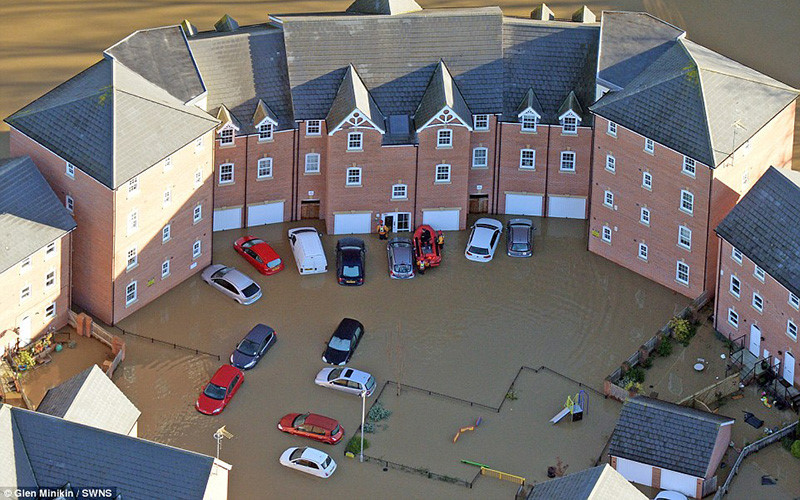 Xe và nhà cửa bị ngập trong biển nước. (ảnh: SWNS).