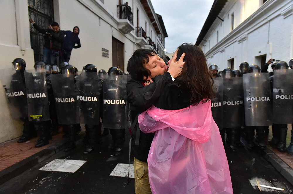 Một cặp đôi ôm hôn nhau trước hàng cảnh sát trật tự trong khi các nhà hoạt động đối lập biểu tình chống chính quyền Tổng thống Ecuador Rafael Correa tại Quito hôm 19/3.