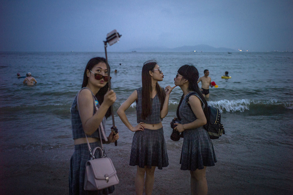 Phụ nữ Trung Quốc tạo dáng chụp ảnh bên bãi biển Thanh Đảo, nằm ở phía Đông tỉnh Sơn Đông, Trung Quốc hôm 24/7.