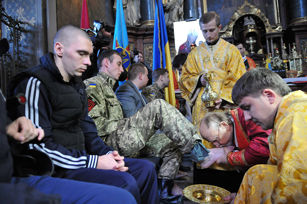 Các tu sỹ người Ukraine của Giáo hội Công giáo Hy Lạp rửa và hôn bàn chân của các binh lính bị thương trong buổi lễ tôn giáo truyền thống ngày Thứ năm rửa chân tại thành phố Lviv, phía Tây Ukraine hôm 9/4.