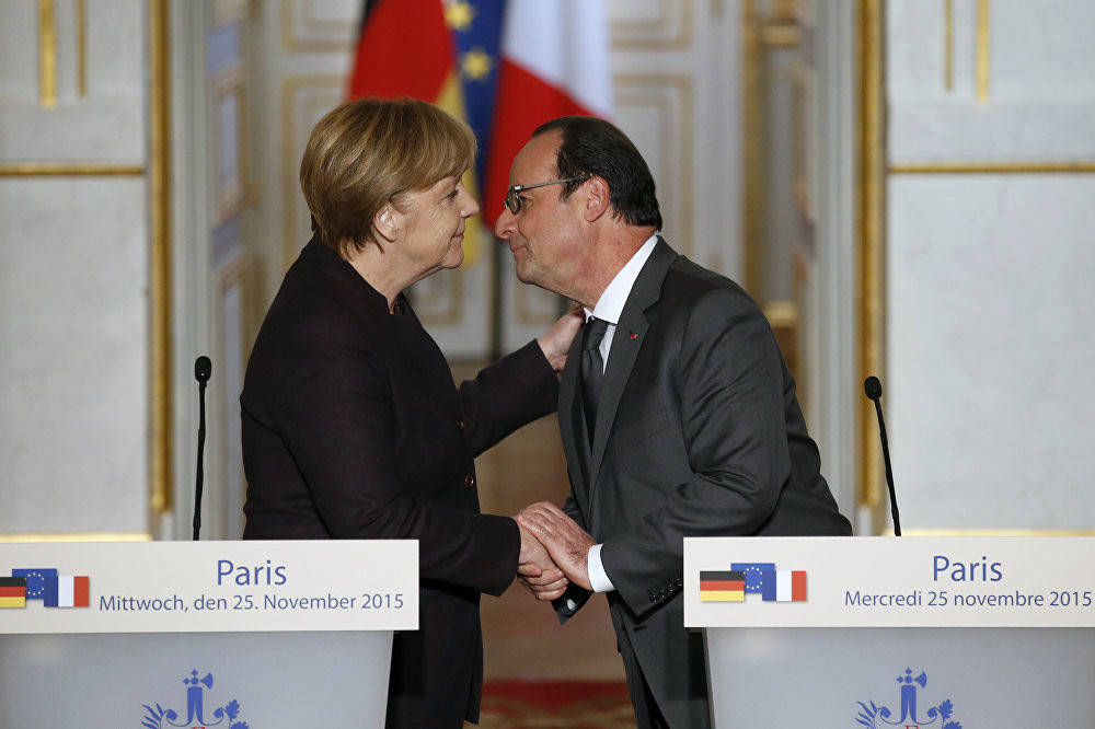 Tổng thống Pháp Francois Hollande (phải) ôm hôn Thủ tướng Đức Angela Merkel vào cuối buổi họp báo chung tại Điện Elysee, Paris hôm 25/11.