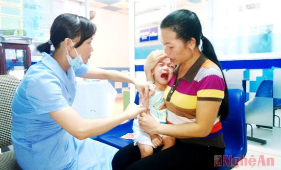 Nhân viên Trung tâm Y tế Dự phòng tỉnh tiêm vắc-xin phòng bệnh viêm não Nhật Bản cho trẻ em.